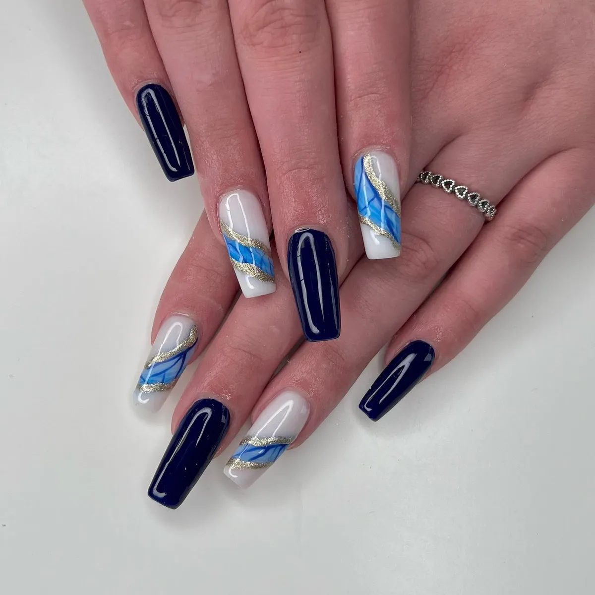 Glossy navy nails with blue and gold marble accents by V Nails Lacombe